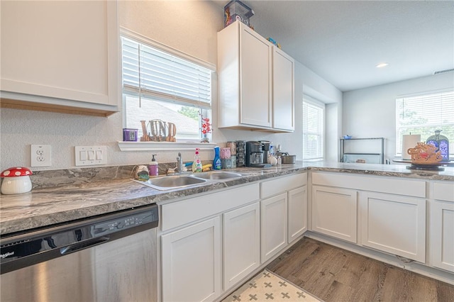 975 Harper Ln, Bryan, TX 77803 - kitchen with stainless steel dishwasher, white cabinetry, a sink, and light wood-style flooring
