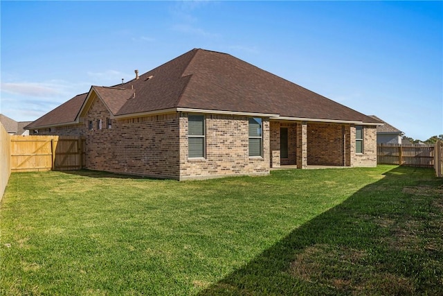 rear view of house featuring a yard