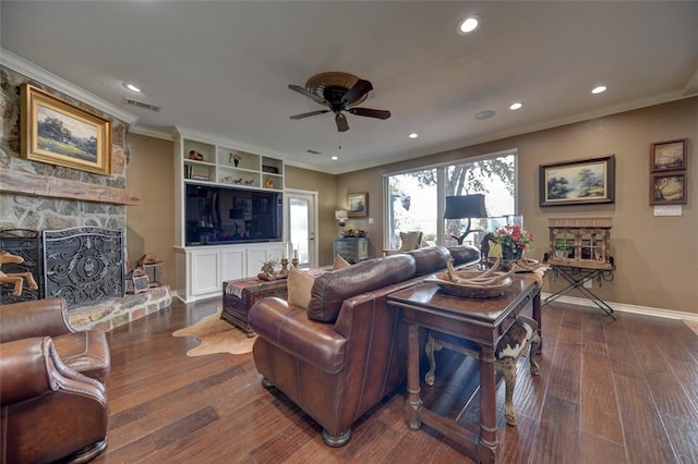 living room with built in shelves, ceiling fan, a fireplace, and dark wood-type flooring