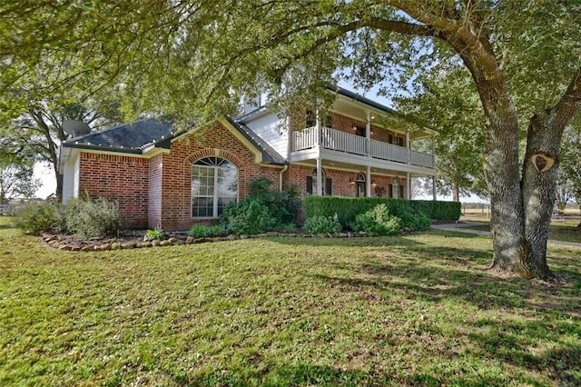 view of front facade featuring a balcony and a front yard