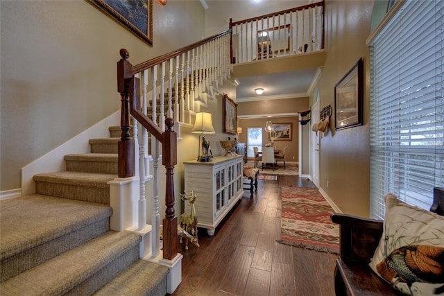 staircase featuring hardwood / wood-style floors, ornamental molding, and an inviting chandelier