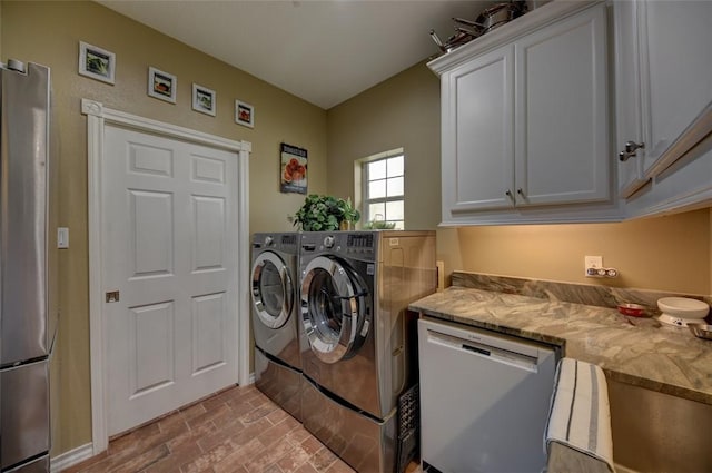 washroom featuring cabinets and washing machine and clothes dryer