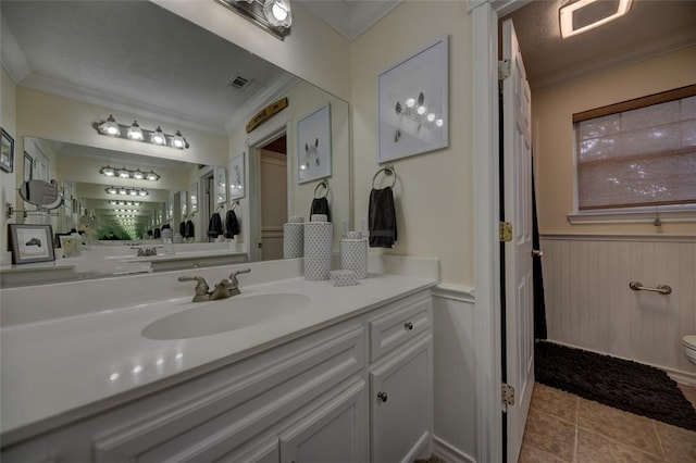 bathroom with tile patterned floors, vanity, ornamental molding, and toilet