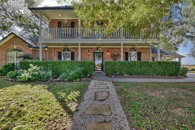 view of front of home featuring a balcony and a front yard