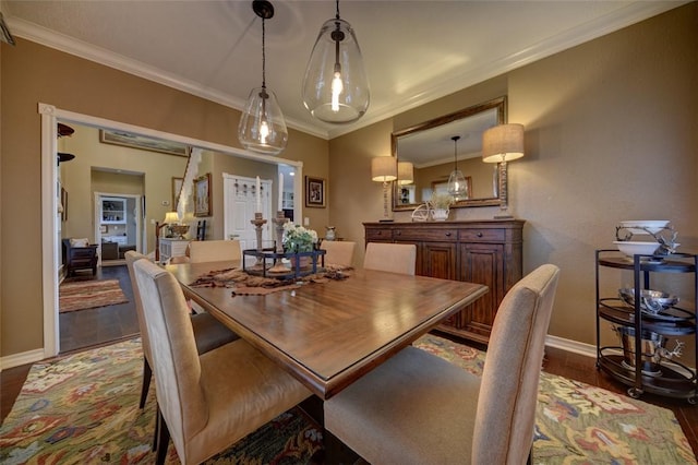 dining space with crown molding and dark wood-type flooring