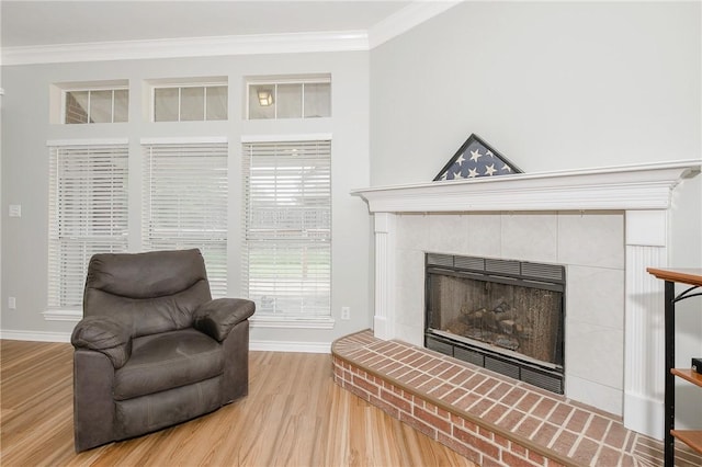 living area with hardwood / wood-style flooring and crown molding