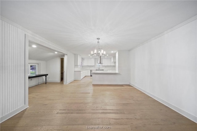 interior space with a chandelier, ornamental molding, light hardwood / wood-style floors, and lofted ceiling