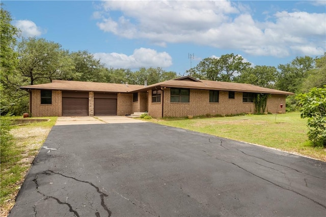 16414 Calumet Trl, College Station, TX 77845 - ranch-style house featuring a garage, asphalt driveway, brick siding, and a front yard