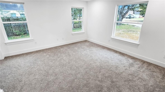 carpeted spare room with baseboards