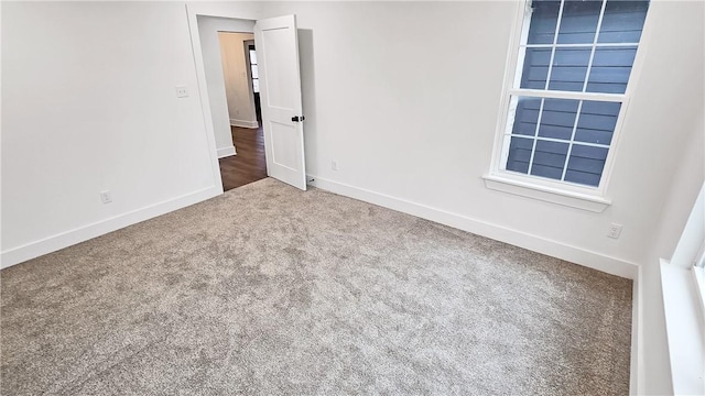 spare room featuring baseboards and carpet flooring