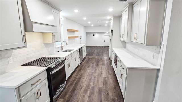 kitchen featuring black gas range oven, open shelves, premium range hood, dark wood-style flooring, and a sink