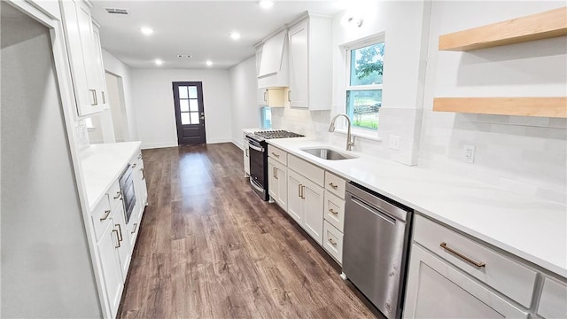 kitchen with visible vents, a sink, premium range hood, stainless steel appliances, and open shelves