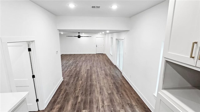 corridor with recessed lighting, baseboards, visible vents, and dark wood-style flooring