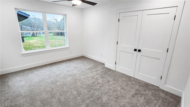 unfurnished bedroom with a closet, a ceiling fan, baseboards, and carpet floors