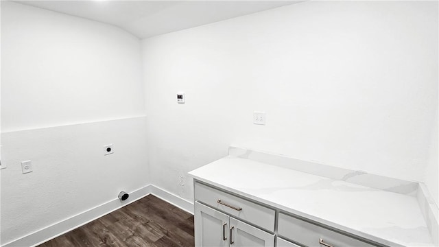 washroom featuring electric dryer hookup, baseboards, dark wood finished floors, and laundry area