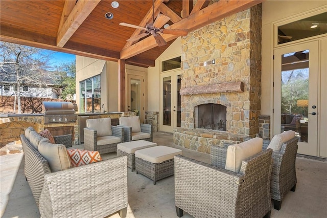 view of patio with an outdoor living space with a fireplace, exterior kitchen, and area for grilling