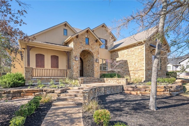 view of front facade featuring stone siding, a porch, and stucco siding