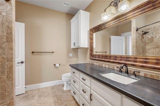 full bathroom with toilet, vanity, tiled shower, baseboards, and tile patterned floors