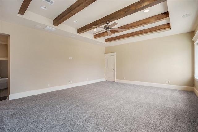 spare room featuring carpet flooring, visible vents, a ceiling fan, baseboards, and beamed ceiling