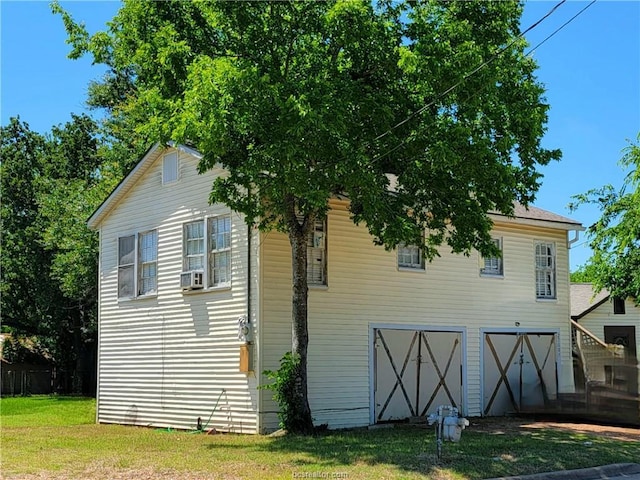 view of side of property featuring a garage and a yard