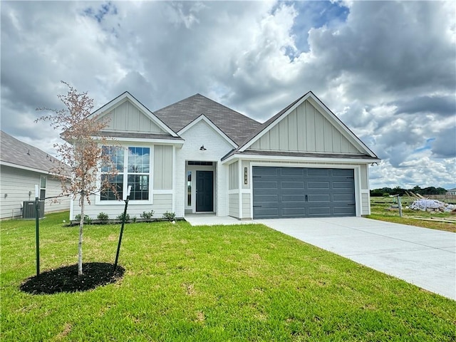 view of front of house featuring central AC unit, a garage, and a front lawn