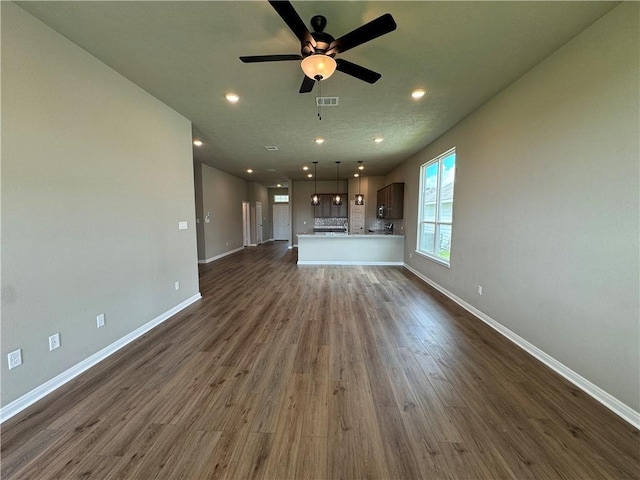 unfurnished living room with ceiling fan and dark hardwood / wood-style flooring