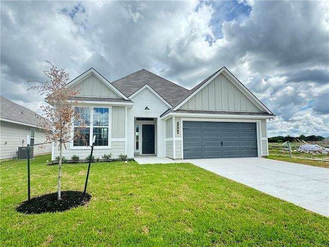 view of front of property with a front yard, a garage, and central AC unit