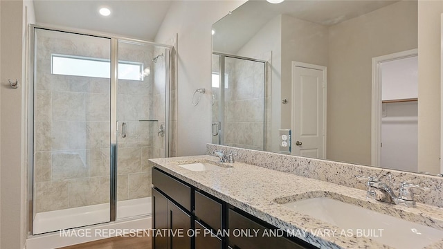 bathroom featuring a shower with shower door and vanity