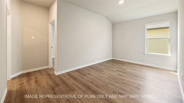 unfurnished room with vaulted ceiling and hardwood / wood-style flooring