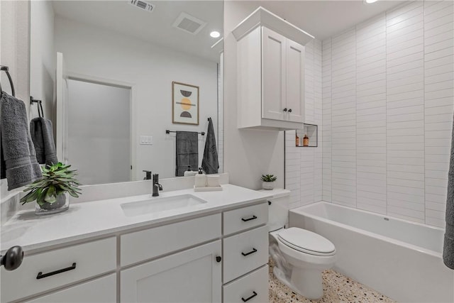 full bathroom featuring vanity, tiled shower / bath combo, and toilet