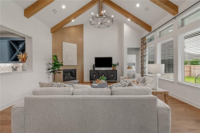 living room with beam ceiling, high vaulted ceiling, light hardwood / wood-style flooring, and a notable chandelier