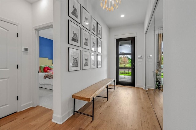 doorway featuring light hardwood / wood-style floors and an inviting chandelier