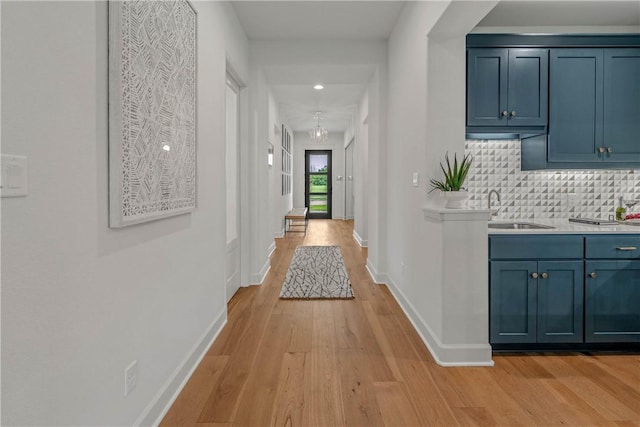 corridor featuring light wood-type flooring and sink