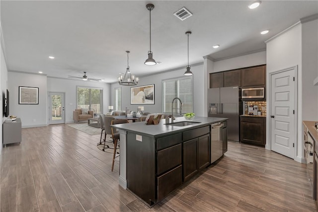 1649 Briscoe Manor Ct, College Station, TX 77845 - kitchen with appliances with stainless steel finishes, a sink, ornamental molding, a ceiling fan, and dark brown cabinetry