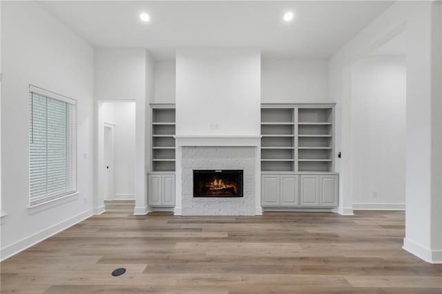 5020 Toscana Loop, Bryan, TX 77802 - unfurnished living room with recessed lighting, baseboards, a stone fireplace, and wood finished floors