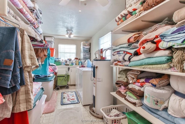 washroom with water heater, washer and clothes dryer, and light tile patterned floors