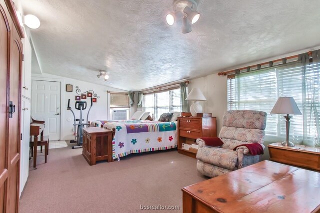 bedroom featuring light colored carpet, a textured ceiling, and vaulted ceiling