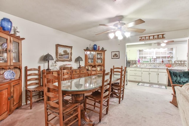 dining area featuring light carpet and ceiling fan