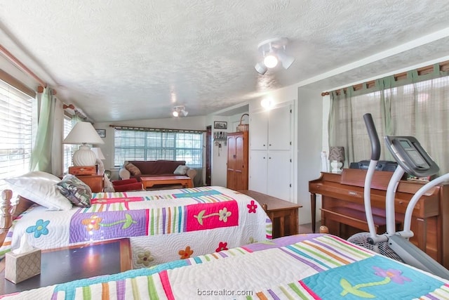 bedroom featuring a textured ceiling and vaulted ceiling