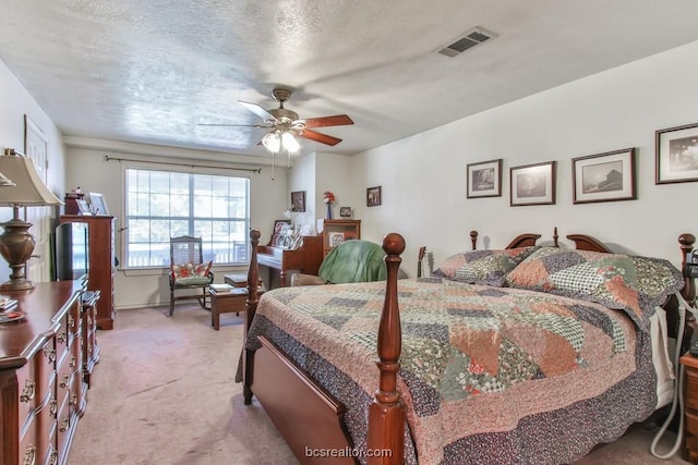 carpeted bedroom featuring a textured ceiling and ceiling fan