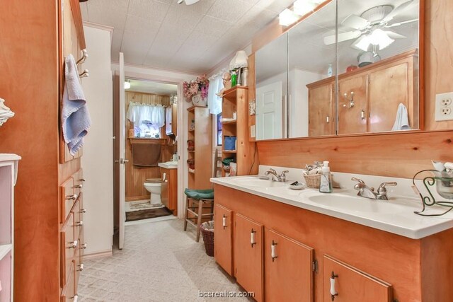 bathroom with vanity, toilet, ceiling fan, and ornamental molding