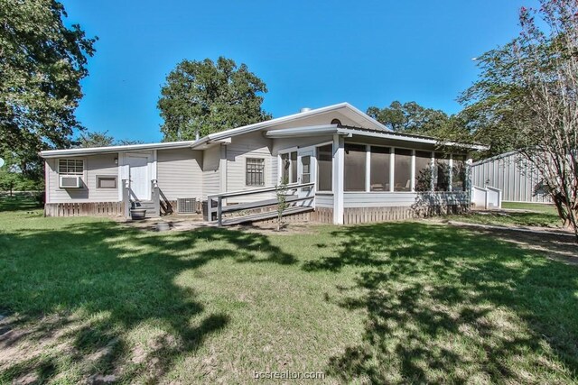 rear view of house featuring a yard, cooling unit, and a sunroom