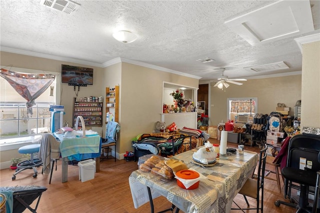 dining area with ceiling fan, crown molding, a textured ceiling, and hardwood / wood-style flooring