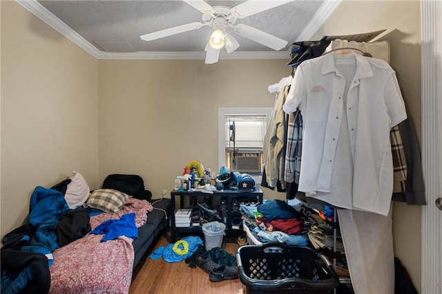 bedroom with a textured ceiling, ceiling fan, ornamental molding, and wood-type flooring