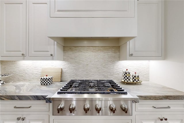 kitchen featuring decorative backsplash, light stone countertops, white cabinetry, and stainless steel gas cooktop