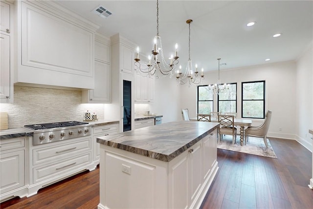 kitchen featuring white cabinetry, a center island, dark wood-type flooring, and stainless steel gas cooktop