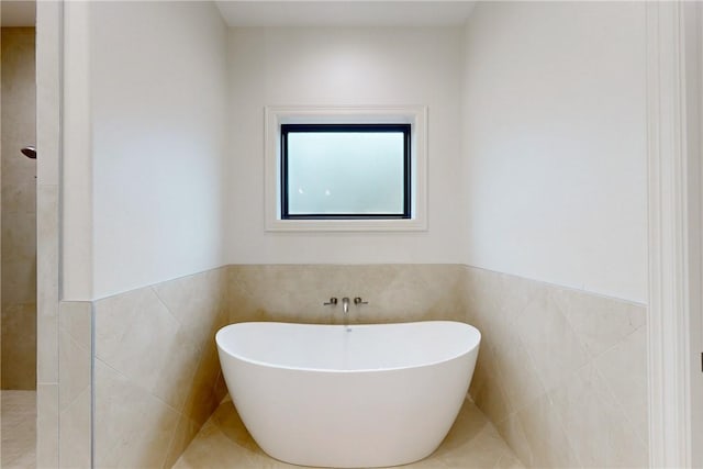 bathroom with tile walls and a tub