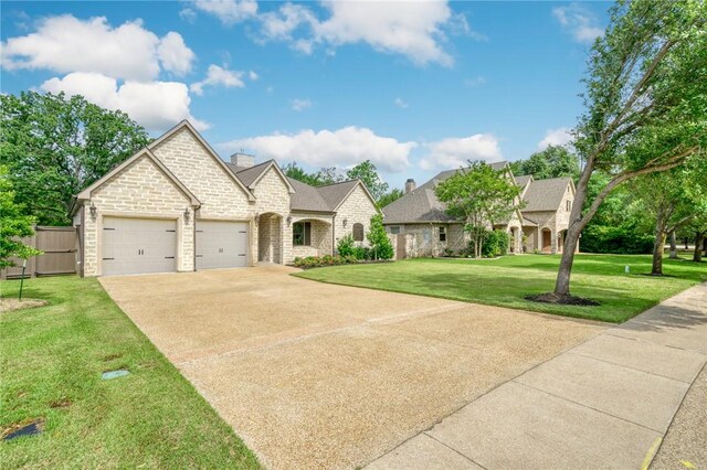 3317 Legacy Ct, Bryan, TX 77802 - french country style house with a garage, stone siding, driveway, and a chimney
