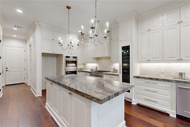 kitchen with white cabinets, dark hardwood / wood-style flooring, a kitchen island, and hanging light fixtures