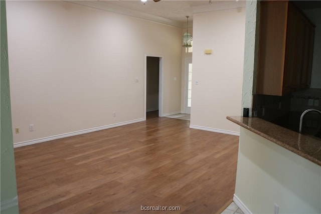 unfurnished living room featuring hardwood / wood-style flooring and ornamental molding